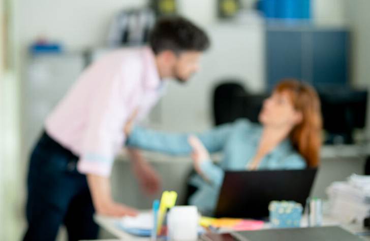 Woman pushing man away at work - Sexual Harassement